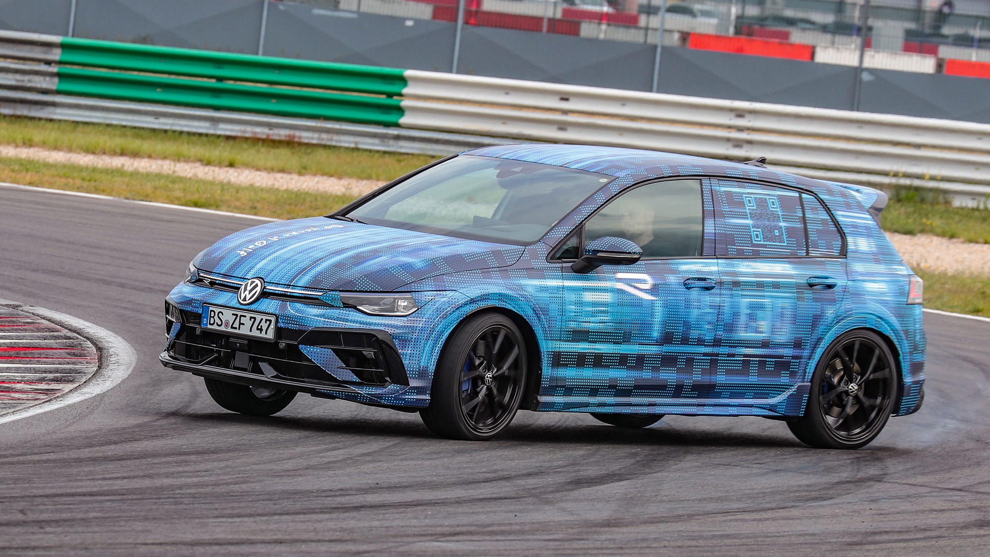 Volkswagen Golf R prototype review: front three quarter cornering, on a race track, oversteer, camo wrap