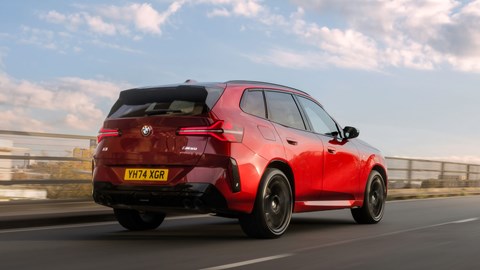BMW X3 (2024) review: rear three quarter driving, low angle, red paint