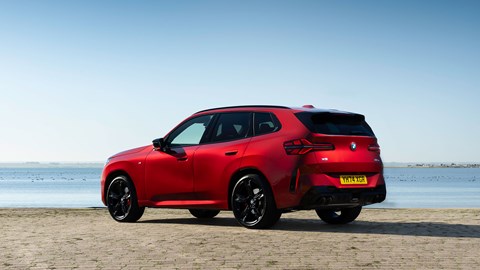 BMW X3 (2024) review: rear three quarter static, red paint, beach