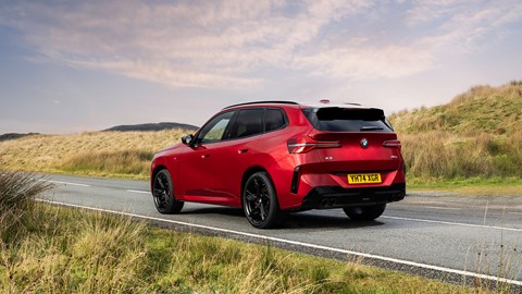 BMW X3 (2024) review: rear three quarter static, red paint, British B-road