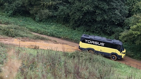 Torsus Praetorian review - side, wide, yellow, driving downhill offroad