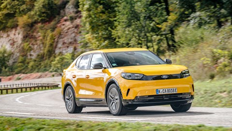 Ford Capri (2024) review: front three quarter cornering, yellow paint, high angle, uphill