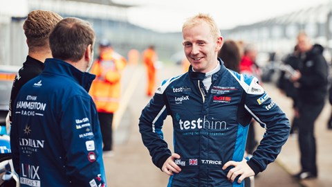 Image of Porsche Carrera Cup GB driver Toby Trice in conversation with team members in the pitlane at Silverstone Circuit