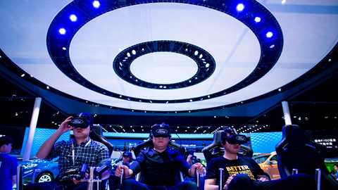 Showgoers try out virtual reality goggles on the Ford stand at Shanghai (Getty)