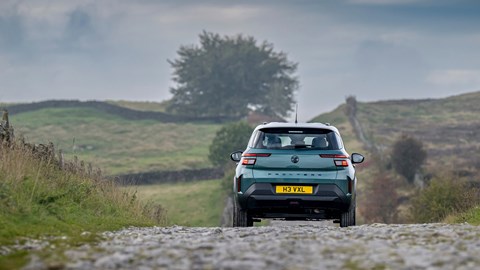 Front view of a teal Vauxhall Frontera Hybrid with a white roof driving along a country lane