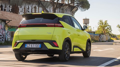 BYD Dolphin Surf (2025): rear three quarter static, low angle, green paint, city background