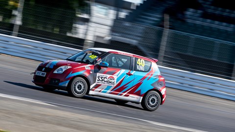 Image of Graham King's Suzuki Swift Sport race cars at Brooklands corner at Silverstone circuit