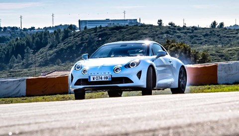 Alpine A110 doing a skid, front three quarter, white paint