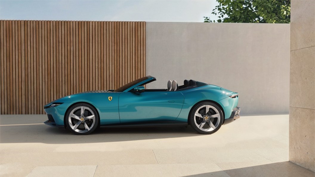 Ferrari Ferrari: Perfil lateral de un Ferrari Amalfi Spider en acabado celeste, exhibiendo su silueta aerodinámica sin techo y resaltando la integración del chasis de aluminio con la línea de cintura ascendente.