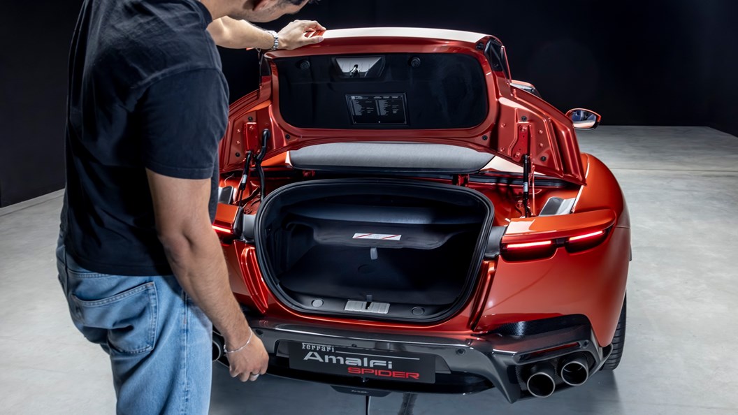 Ferrari Ferrari: Vista posterior de un Ferrari Amalfi Spider con el compartimento de carga abierto, evidenciando la restricción de volumen impuesta por el mecanismo del techo rígido retráctil y la gestión térmica del motor V8 central-delantero.