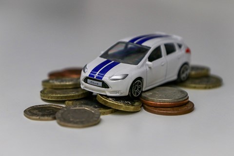 Pay-per-mile eVED scheme: toy car on a pile of coins