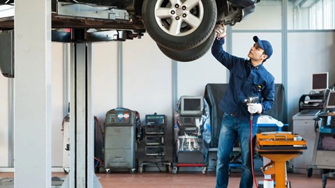 Pay-per-mile eVED scheme: mechanic servicing a car