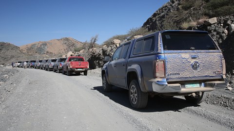 Convoy of dusty VW Amaroks in the Omani mountains