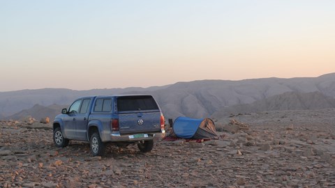 VW Amarok next to tent on rock in Oman