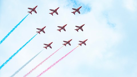 ~Red Arrows flying in formation with their red white and blue vapour trails 