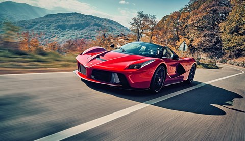 Fastest hybrid cars: Ferrari LaFerrari, front three quarter driving, tree-lined road, red car