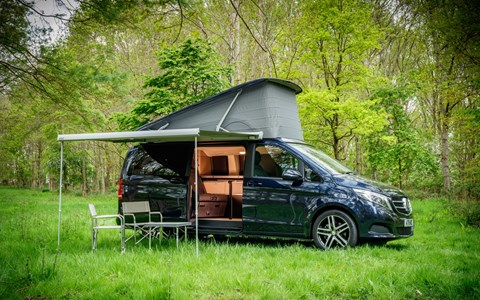 Image of a blue Mercedes Marco Polo pitched up in a woodland glade