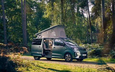 Image of a green Citroen Holiday pitched up in a wood