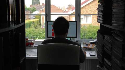 Keith WR Jones deep in thought with a spreadsheet open sat in his library