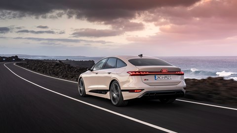 Audi A6 e-tron Sportback: rear three quarter driving, ocean in background, beige paint